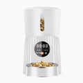 Black and white smart automatic pet feeder with USB cable and mobile app display showing feeding schedule.
