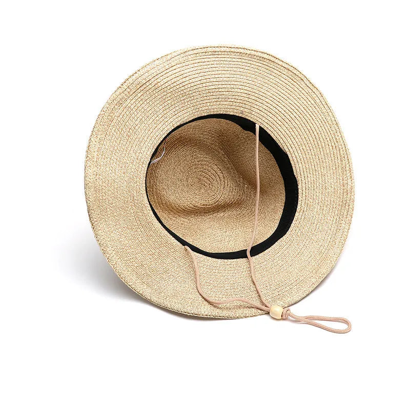 Men's foldable straw sun hat with large brim in beige colour on wooden surface