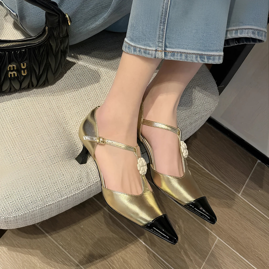 Women's gold stiletto shoe with floral detail, pointed toe, and a shallow cut opening.