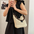 Knitted tote beach bag showing bucket shape, contrast stitching, and zippered internal pocket in black colour