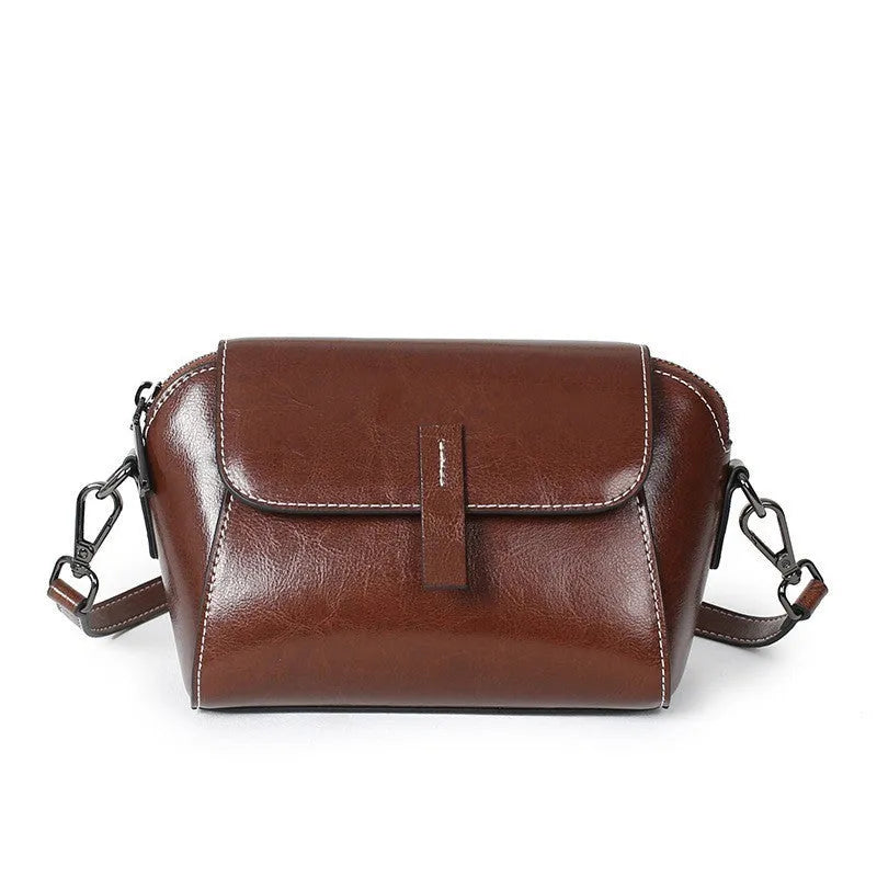 Women's brown cowhide leather shell messenger bag with cross-body strap and multiple internal compartments