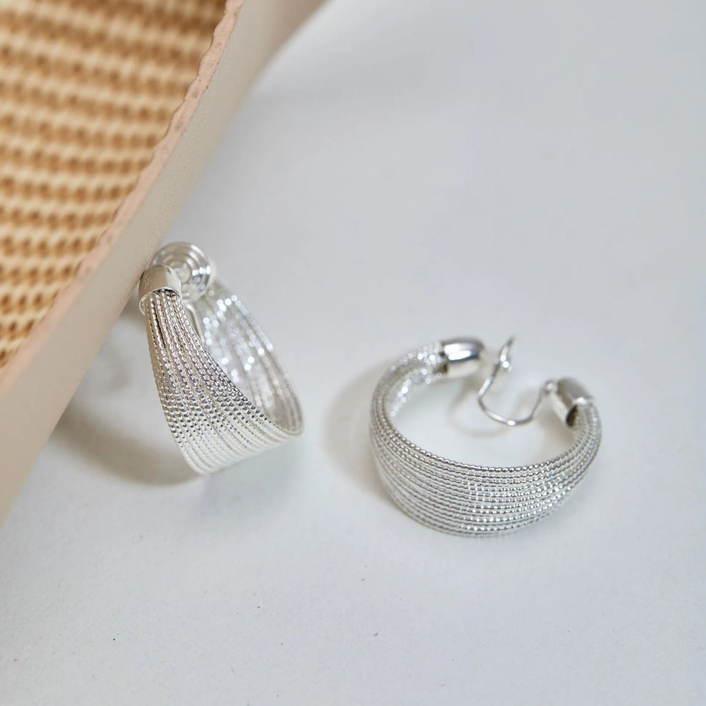 Multi-layer geometric copper earrings with electroplated gold or silver finishes, available as stud or clip styles