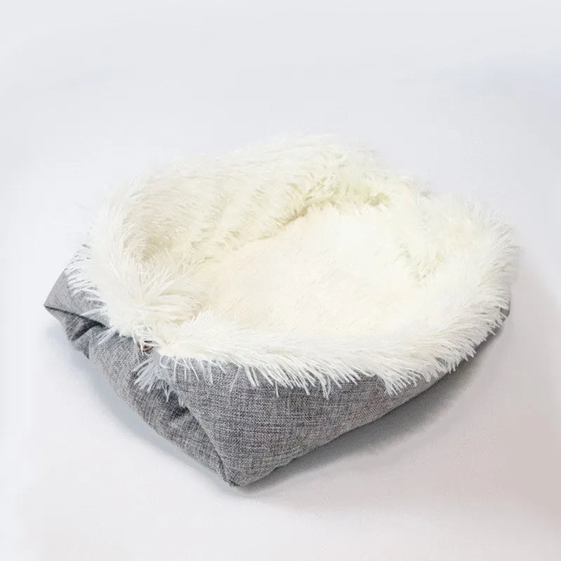 Grey plush pet blanket and bed with raised sides and a black non-slip bottom, shown on a wooden floor.