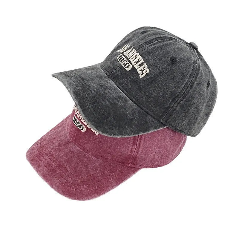 Retro-style adjustable acrylic peaked cap with embroidered letters, shown in a distressed beige colour.