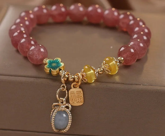 Red women's bracelet with natural strawberry quartz beads, alloy settings, and rhinestone decorative elements