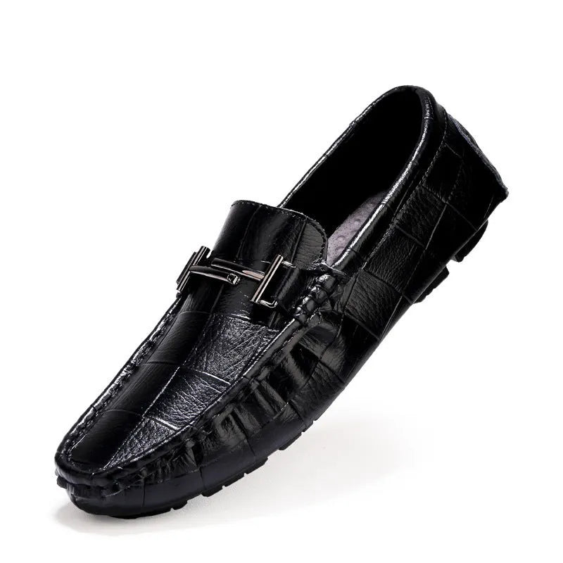 Men's brown leather slip-on loafers with a silver belt buckle detail on the front.