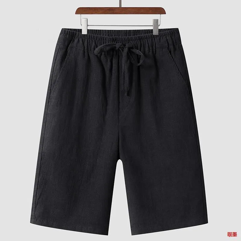 Man wearing beige linen cropped shorts with a loose fit and elasticated waistband.