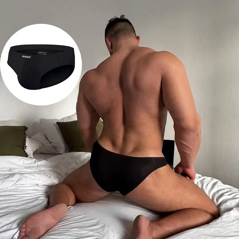 Men's solid colour seamless low-waist briefs in black, shown flat.