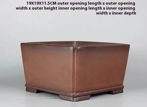 Handmade brown antique flower pot made from purple clay, shown on a surface.