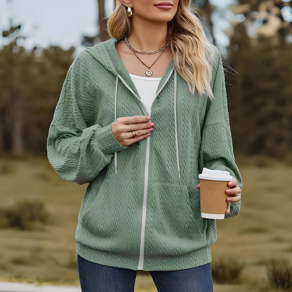 Green women's loose fit hooded sweater coat with a front zip closure on a hanger.