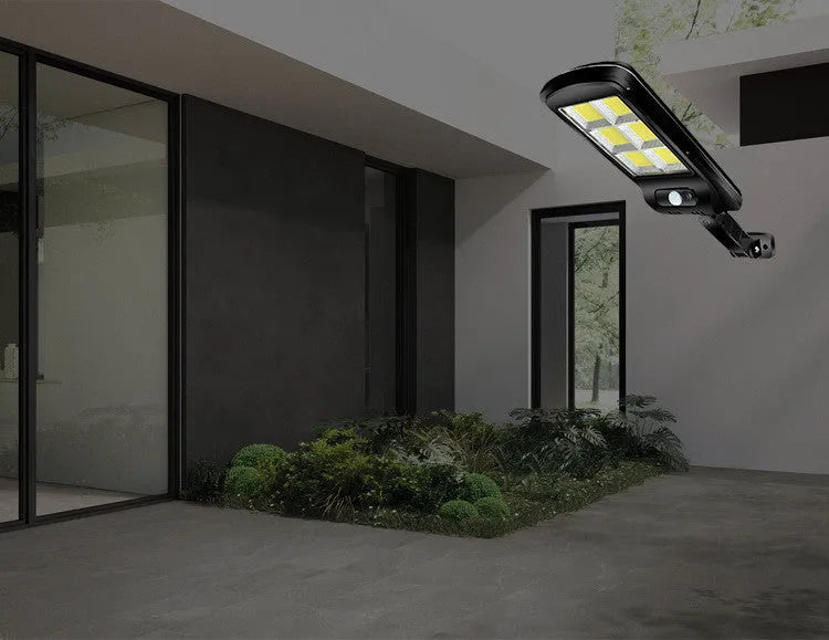 Black solar-powered outdoor security light with motion sensor mounted on a wall.