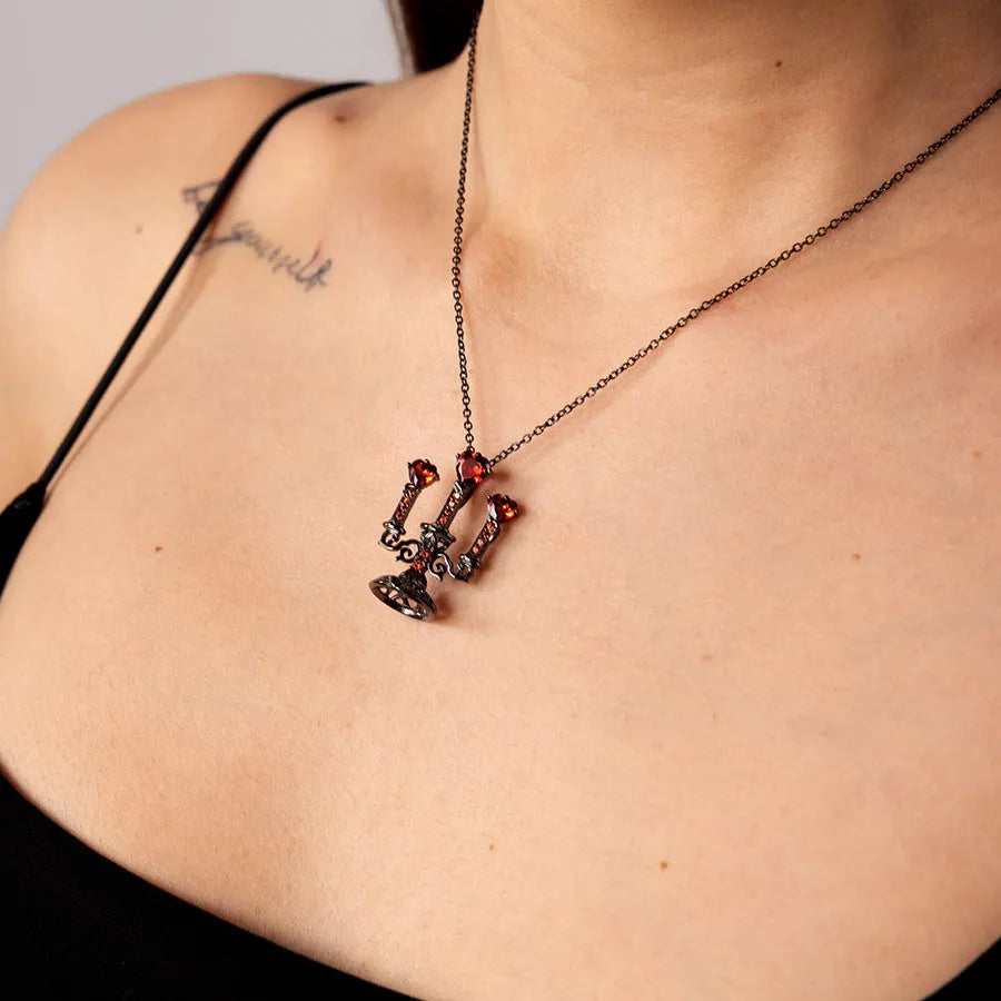 Zinc alloy gothic necklace with hollow candlestick pendant and cross chain on a dark background.