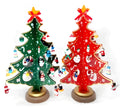 Hand painted wooden Christmas tree decorations in red and green colours on desktop