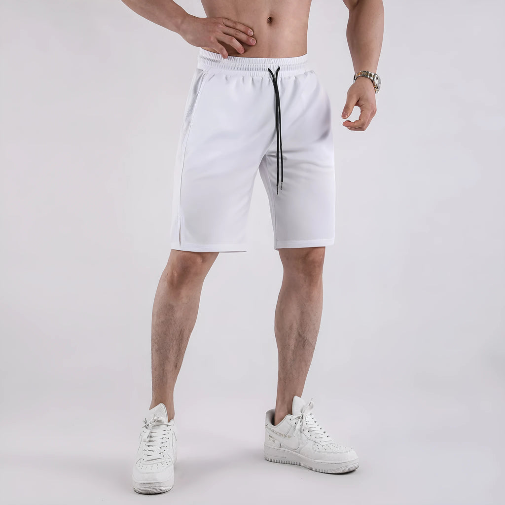 Man wearing loose black capri-length fitness shorts with an elasticated waistband.