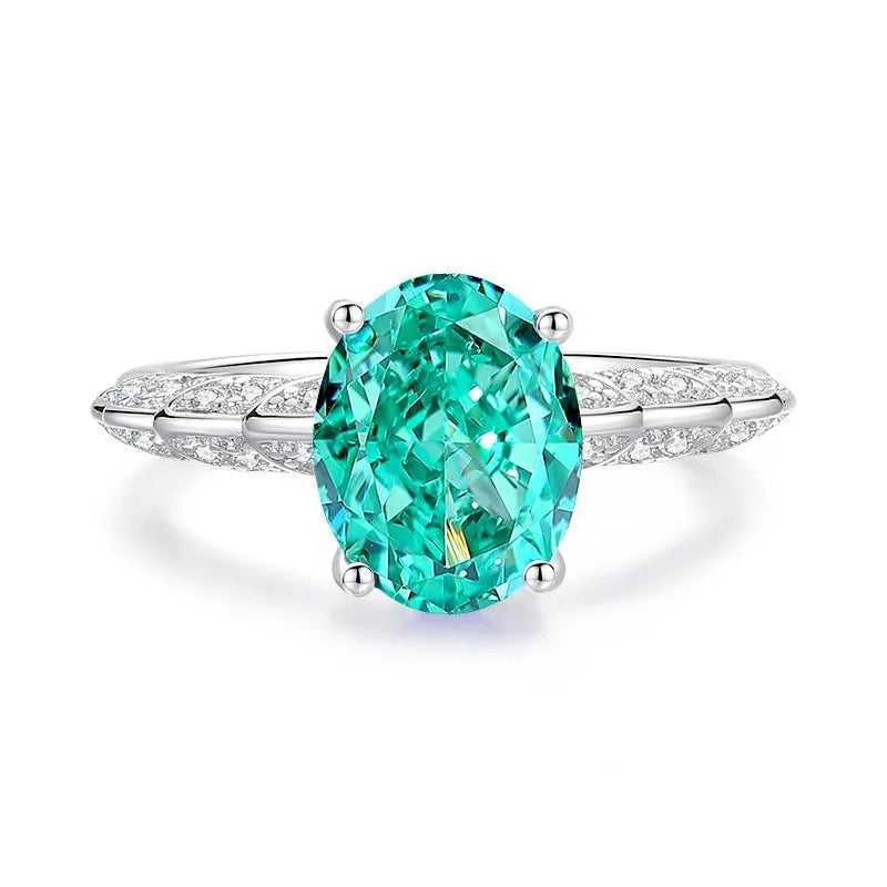 Women's sterling silver ring with a central emerald stone and diamond accent on a geometric band.