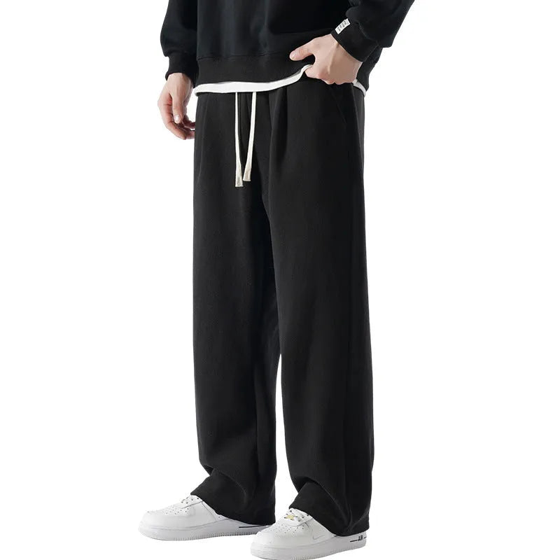 Men's apricot coloured loose-fit fleece-lined winter sports trousers with a drawstring waist laid flat.