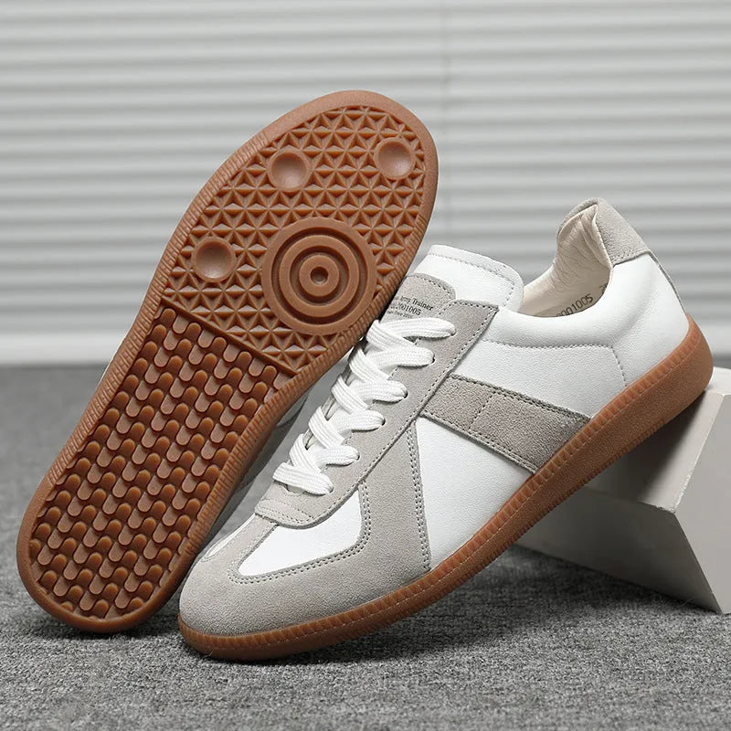 White low-top retro sneakers with mesh lining and rubber soles on a solid background