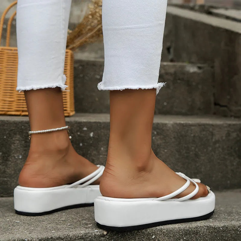 White thick-soled flip-flops with herringbone patterned PU upper and rubber sole.