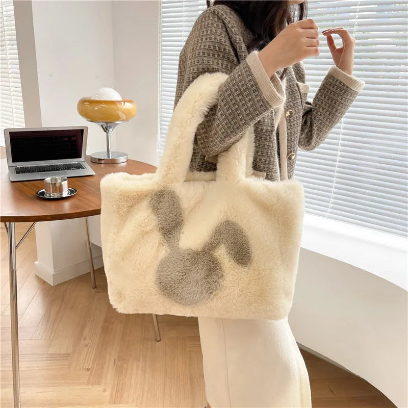Plush shoulder bag with cartoon rabbit ears design in a solid colour.