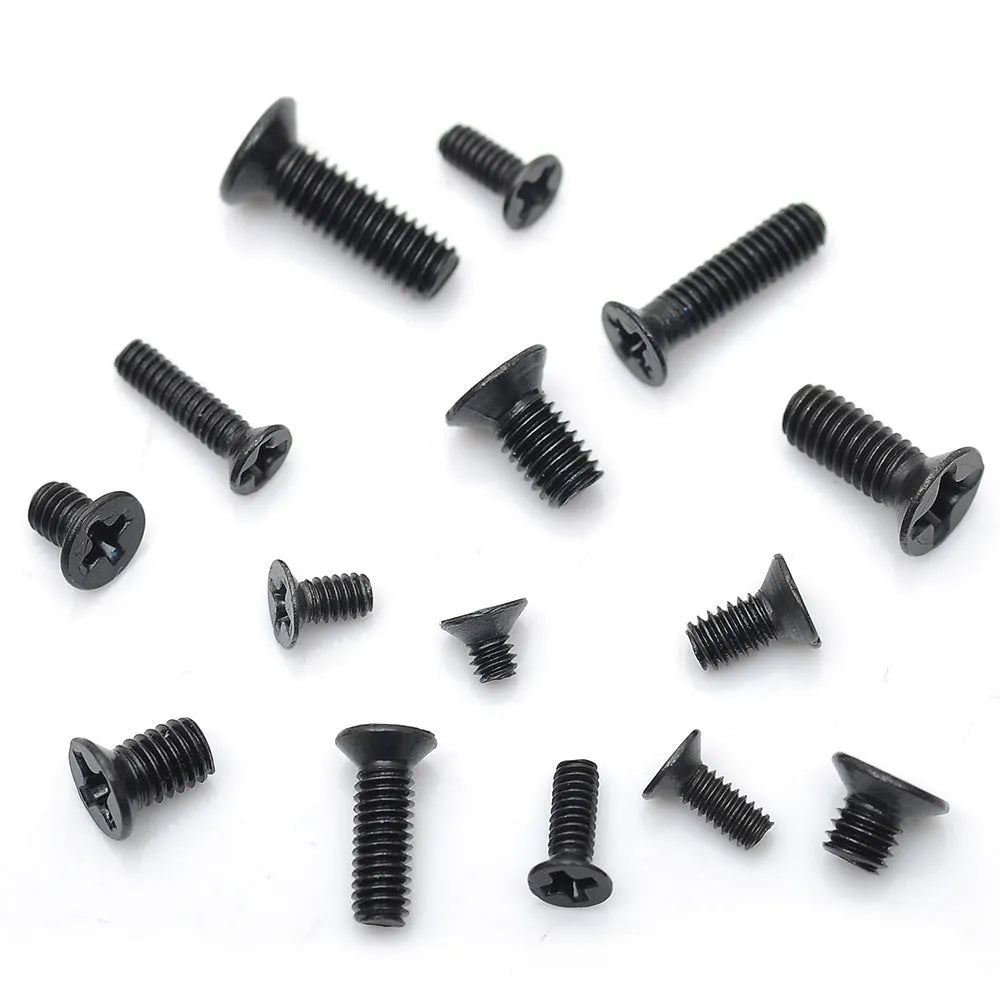 Assortment of small black countersunk head machine screws with cross-head drives for laptop repair.