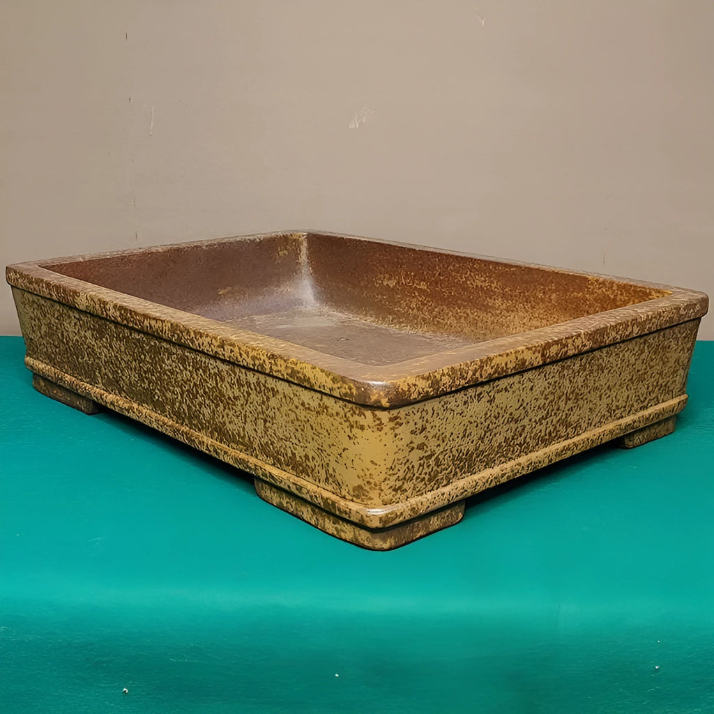 Straight shallow rectangular Yixing zisha purple sand flowerpot on a solid surface.
