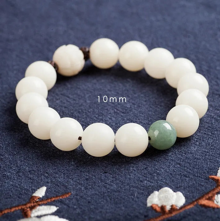 Natural white jade Bodhi bracelet with transfer beads on a neutral background