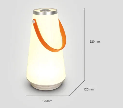 White rechargeable LED bedside lantern with USB cable on a table.
