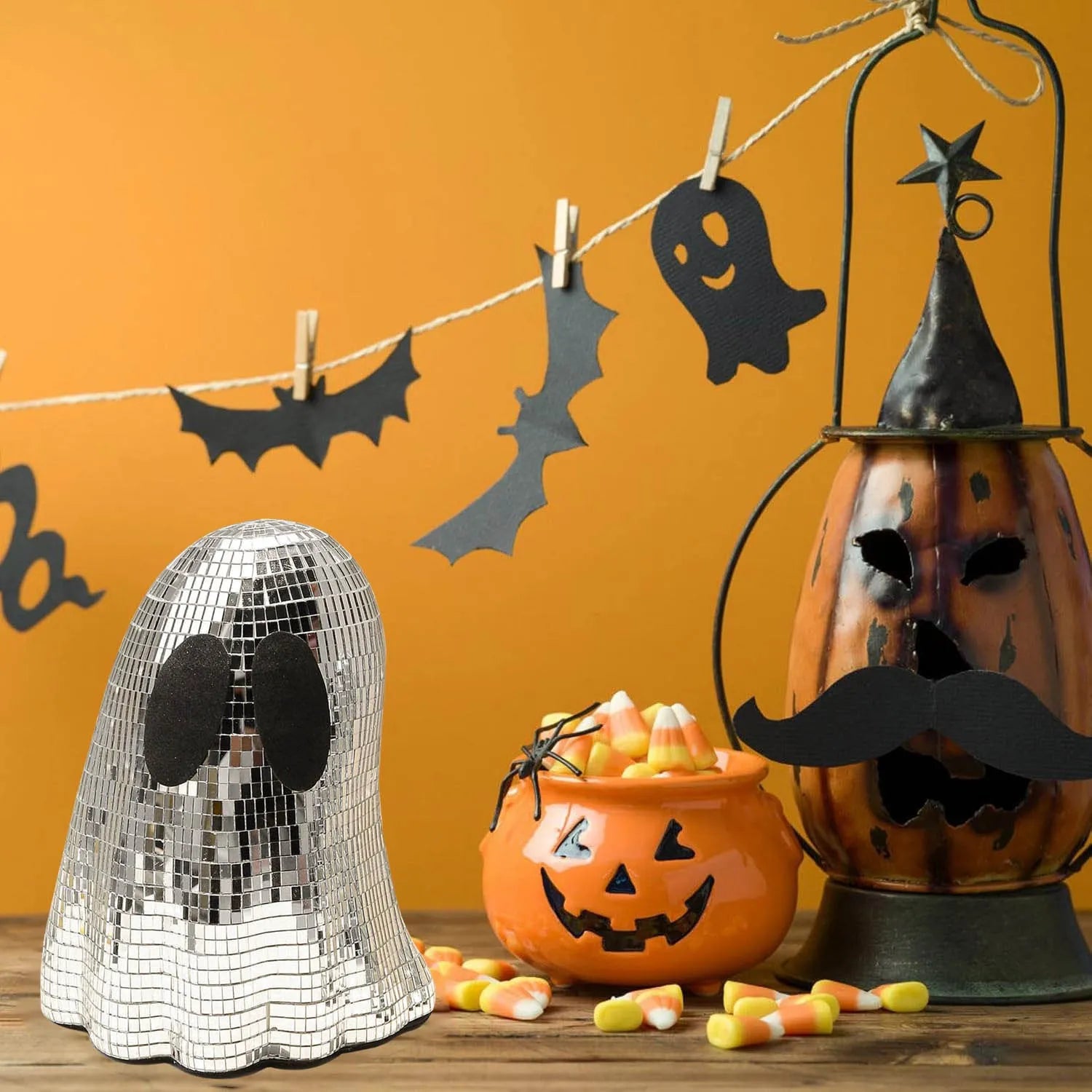 Silver glass Halloween ghost mosaic desktop decoration on a dark surface.