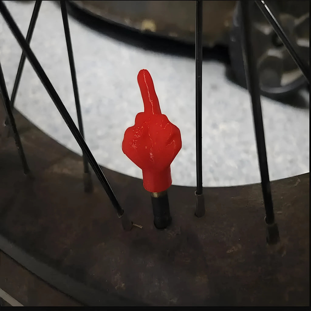 Set of four latex car tyre valve dust caps in black and skin colour tones.