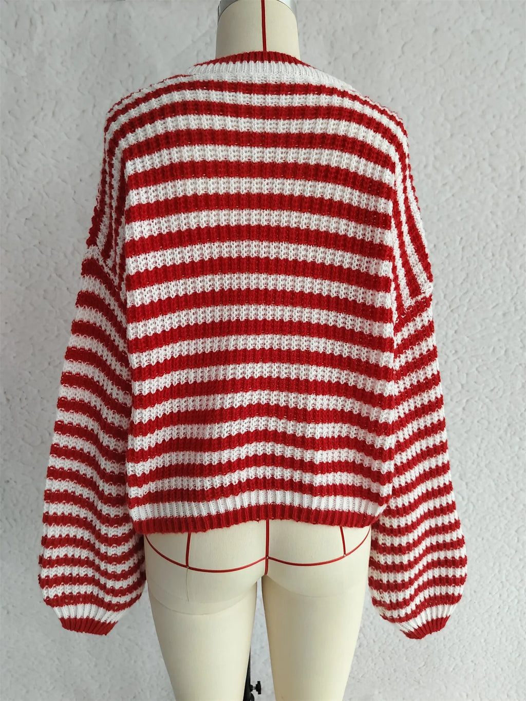 Women's loose vintage stripe knitted pullover sweater in red, shown on a hanger.