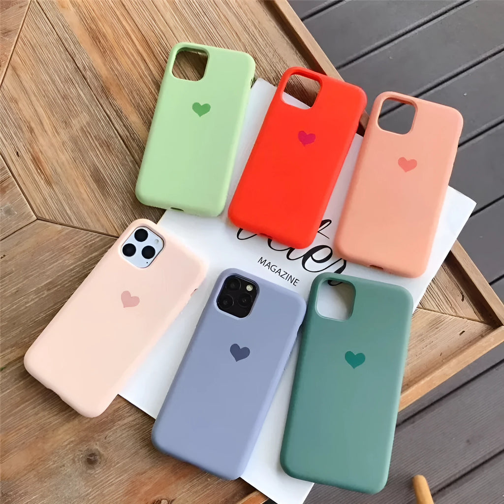 Silicone phone case for iPhone in solid colours including dark green, light pink, and purple.