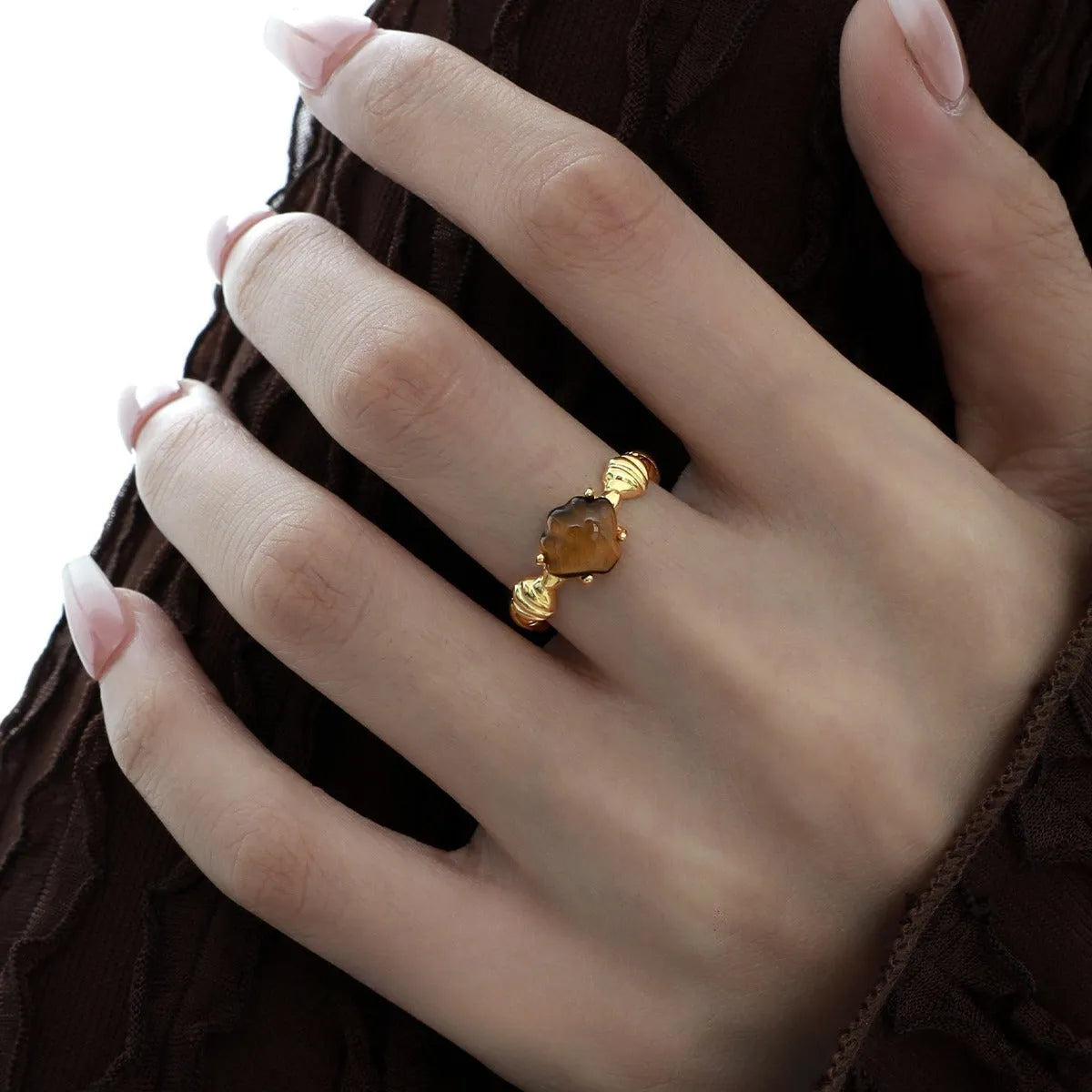 Women's adjustable silver ring with shell design and tiger eye accents in gold electroplated finish.