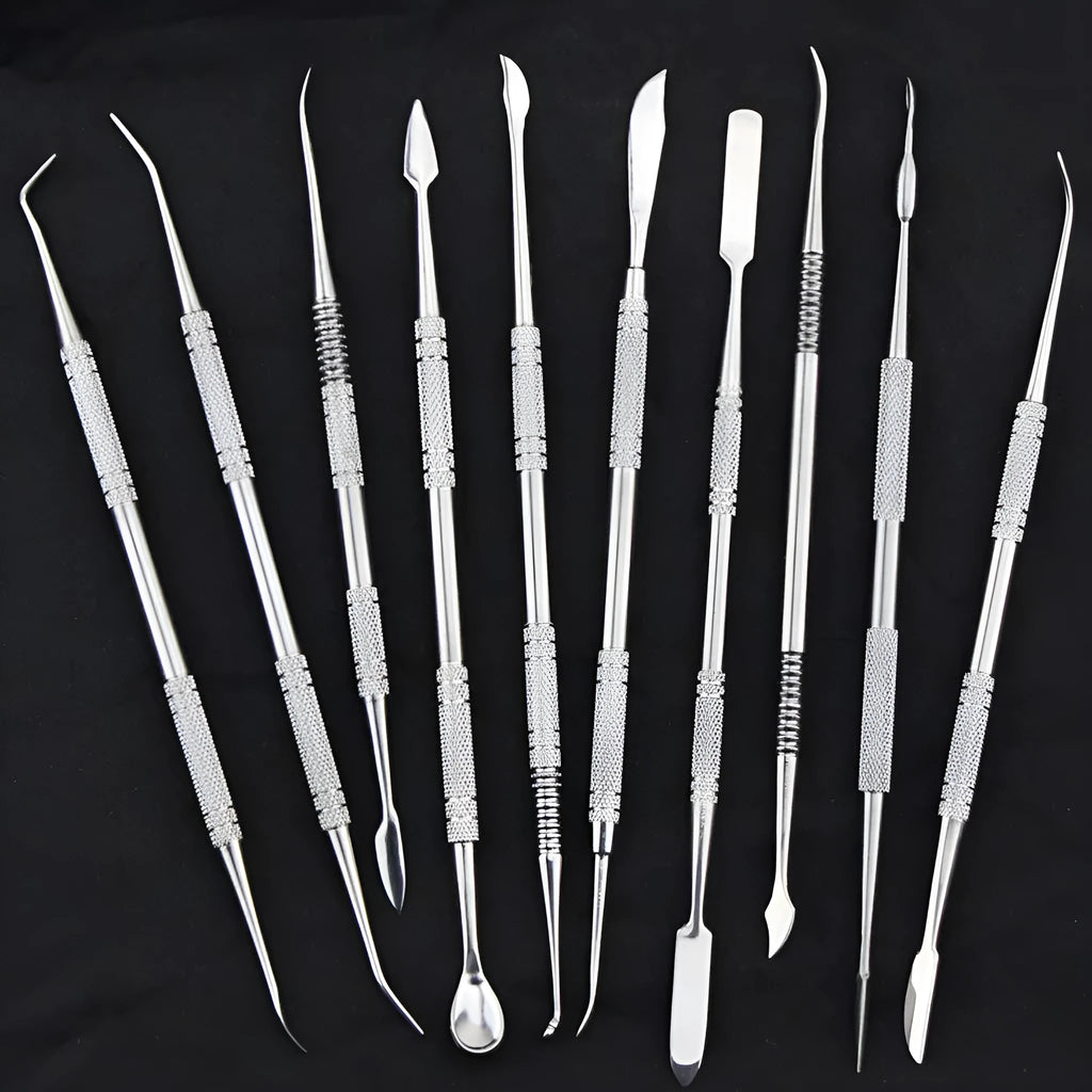 Ten stainless steel clay knives with photo colour handles arranged on a surface for pottery sculpting work.