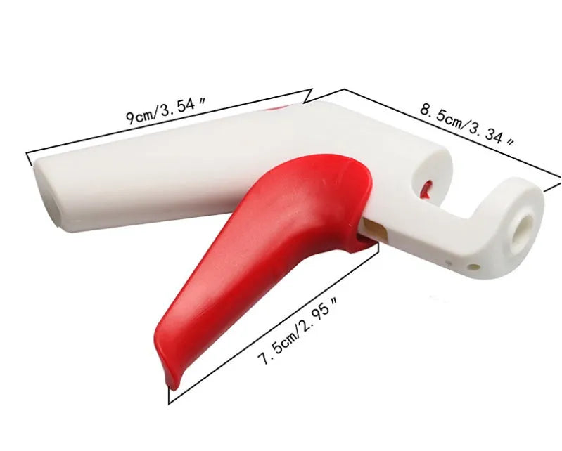 Red and black manual cherry pitter tool with detachable stone catcher on a kitchen worktop.