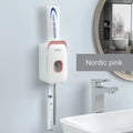 Wall-mounted automatic toothpaste dispenser in blue, grey, or pink colours with a visible dispensing lever.