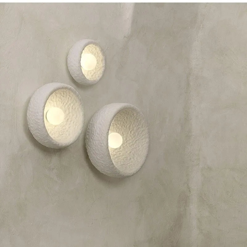 Japanese-style simple silent wall lamp with white resin shade in a modern room setting.