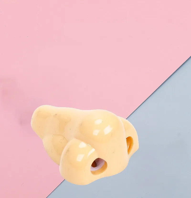 Flesh-coloured plastic geometry-shaped pencil sharpener with a large nostril.
