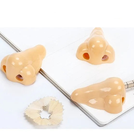 Flesh-coloured plastic geometry-shaped pencil sharpener with a large nostril.