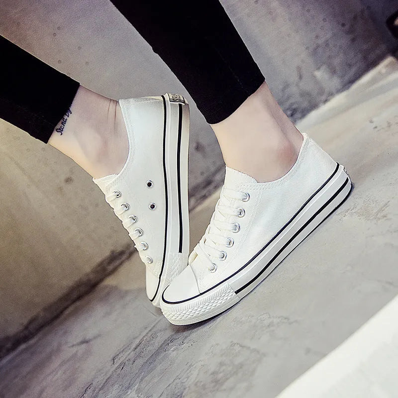 Women's casual canvas shoes in solid colours on a flat sole, showing lace-up fastening.