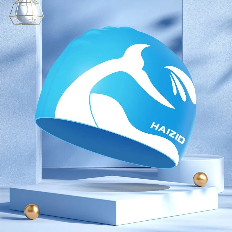 Silicone swim cap with ear protectors in whale tail design, shown in multiple colours.