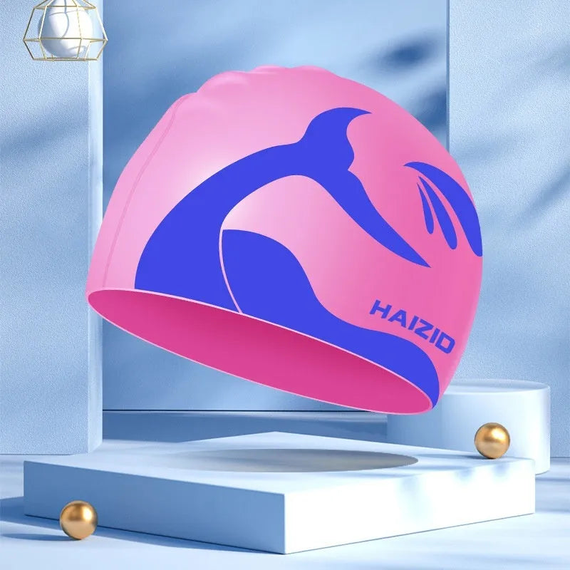Silicone swim cap with ear protectors in whale tail design, shown in multiple colours.