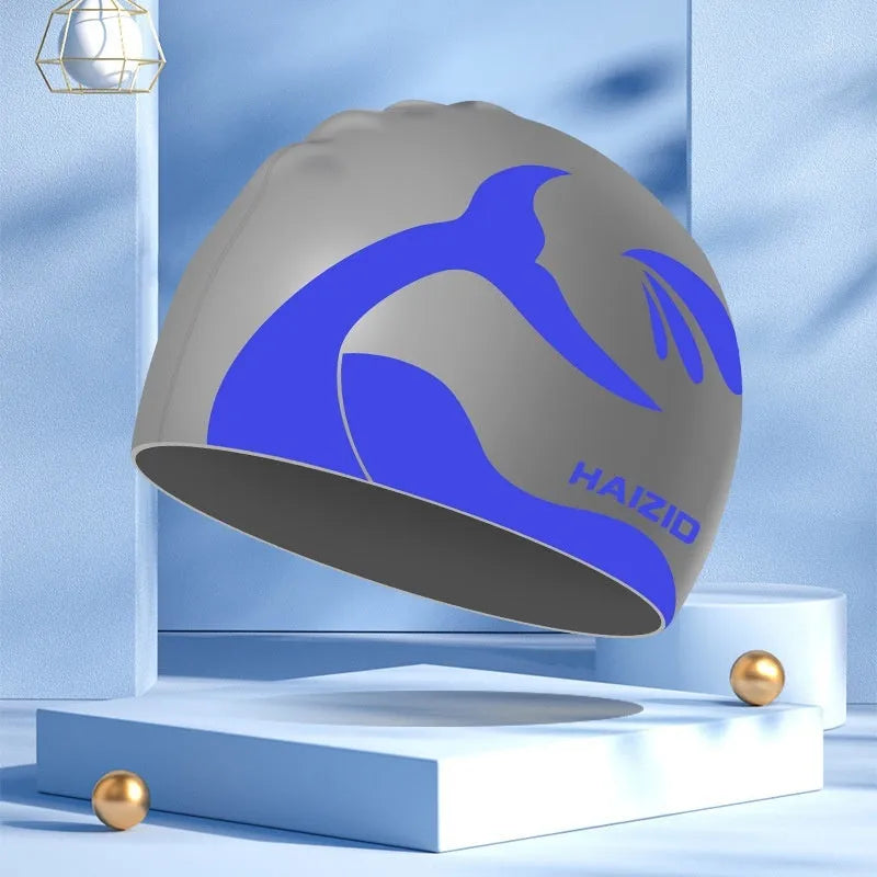 Silicone swim cap with ear protectors in whale tail design, shown in multiple colours.