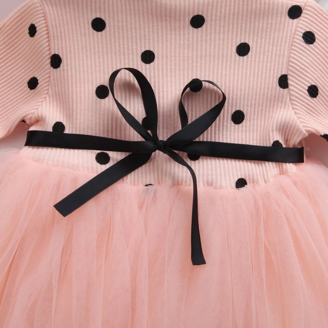 Baby girl in a long sleeve black lace tutu dress, suitable for christenings and parties.