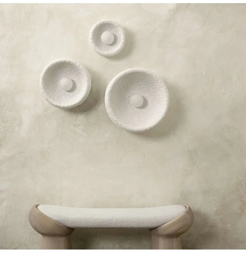 Japanese-style simple silent wall lamp with white resin shade in a modern room setting.