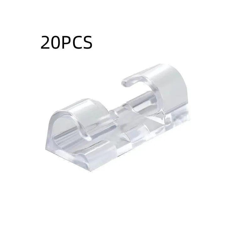 Transparent self-adhesive plastic wire holder snap clips for cable management on a white surface.