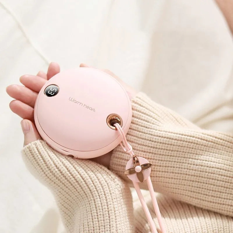 Green Pink or White coloured 5000mAh hand warmer power bank with digital display showing charge level.