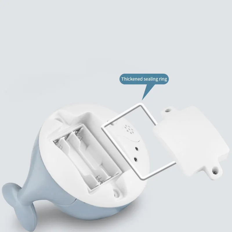 White and blue whale bath toy spraying water with LED lights illuminated