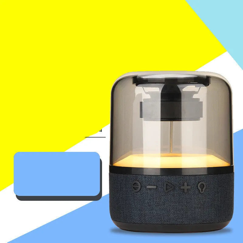 Four-colour light touch wireless Bluetooth speaker with halo lighting effect on a table.