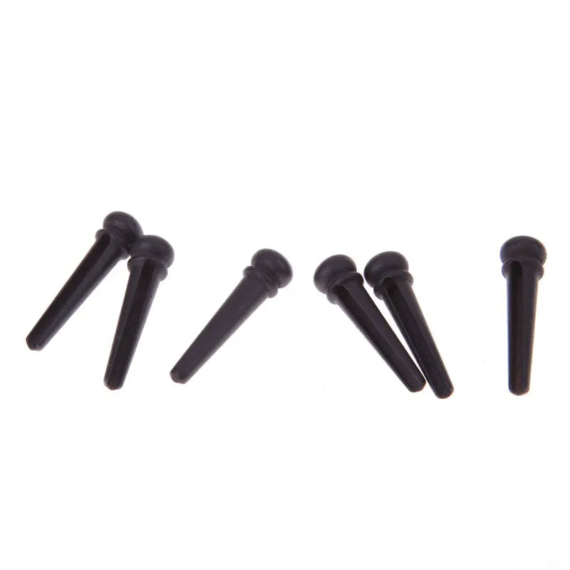 Six ebony folk guitar string nails with matt black finish and 5.3mm bayonet diameter