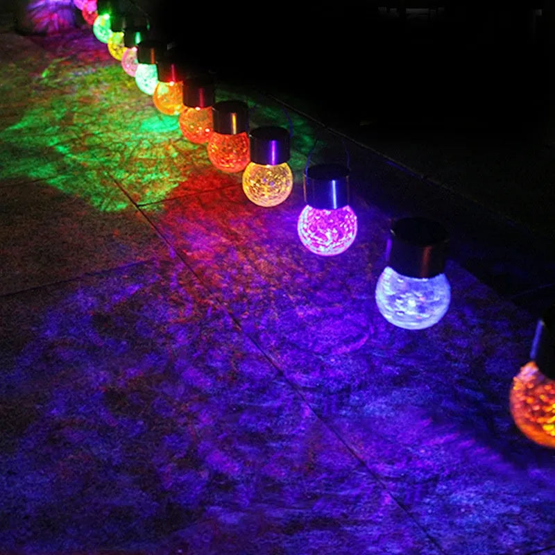 Solar cracked glass pendant light with rubber body and LED glow in garden setting